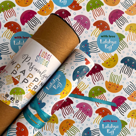 A roll of wrapping paper with a colorful cartoon jellyfish pattern, shown partially unrolled over a matching sheet.