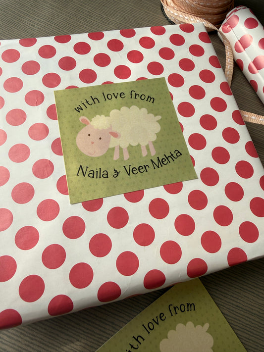 Personalized baby gift wrap featuring a white background with red polka dots and a square olive green label with a sheep illustration and the text 'With love from Naina & Veer Mehta'.