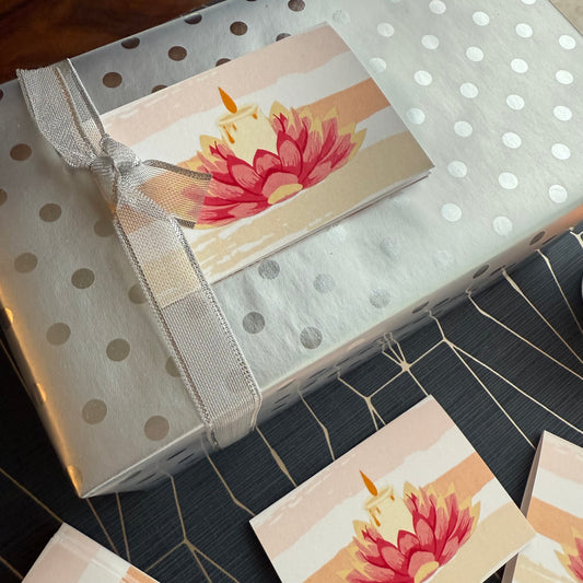 Gift box with ribbon on a polka dot wrapping paper with a lotus design gift tag