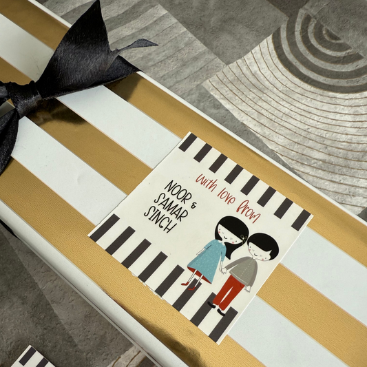 Gift box with striped wrapping paper and a personalized card on a textured surface.
