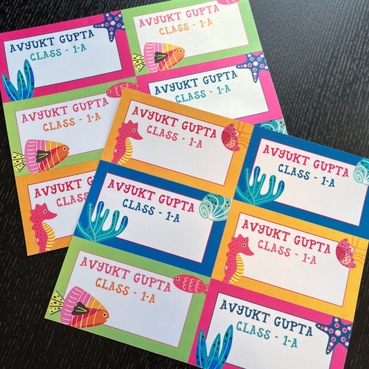 colorful underwater-themed name tags arranged on a dark textured surface. Each tag has a white center with the text bright borders in pink, green, blue, yellow, and orange, decorated with seahorses, fish, and starfish illustrations.