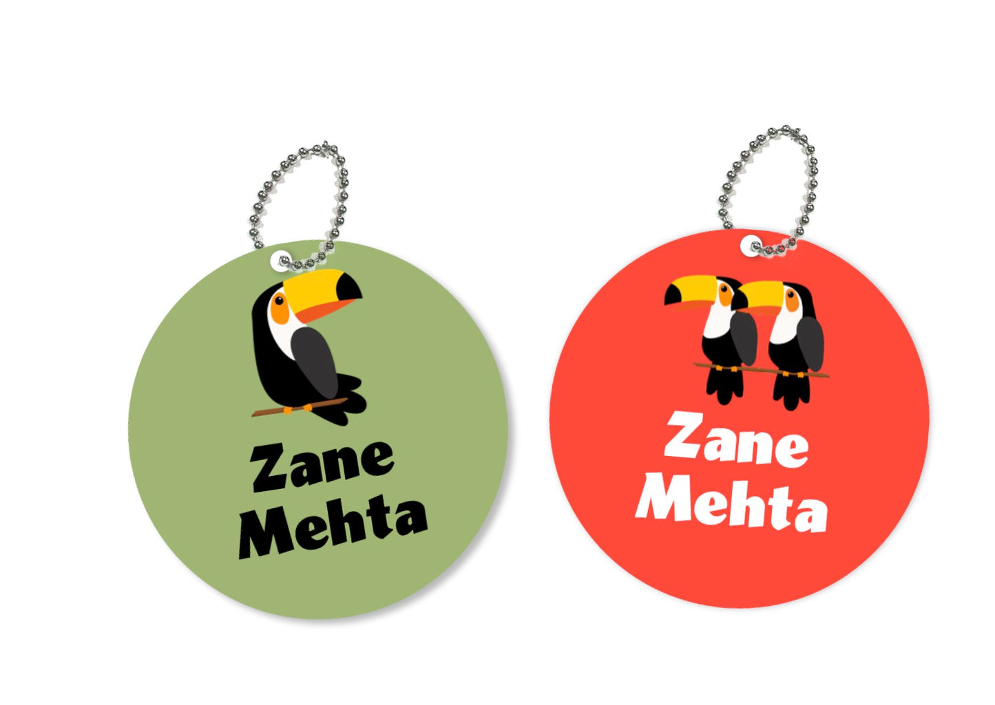 Two round metal bag tags with a toucan design, one green and one red, both with the name 'Zane Mehta' printed on them.