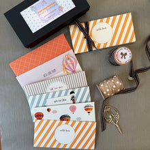 Collection of decorative envelopes with ribbons and scissors on a gray surface