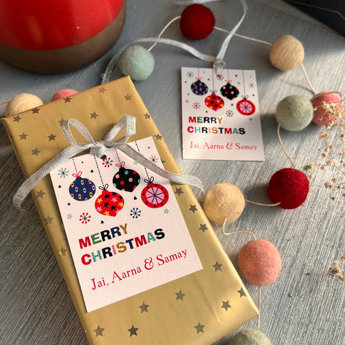 Personalized Christmas gift tags with 'Merry Christmas' text and decorative elements such as snowflakes, ornaments, and gift ribbons.