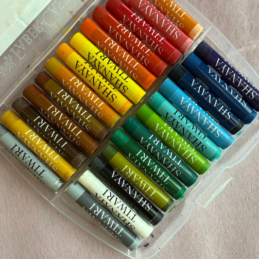 Set of pastel crayons in various colors with personalised name branding on a light background