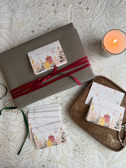 Gift wrapped box with a ribbon and a diwali gift tag on a patterned surface with a candle