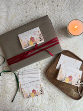 Gift wrapped box with a ribbon and a diwali gift tag on a patterned surface with a candle