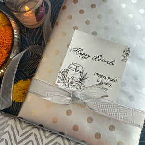 Gift wrapped in polka dot paper with a Diwali card, ribbons, and decorative items.