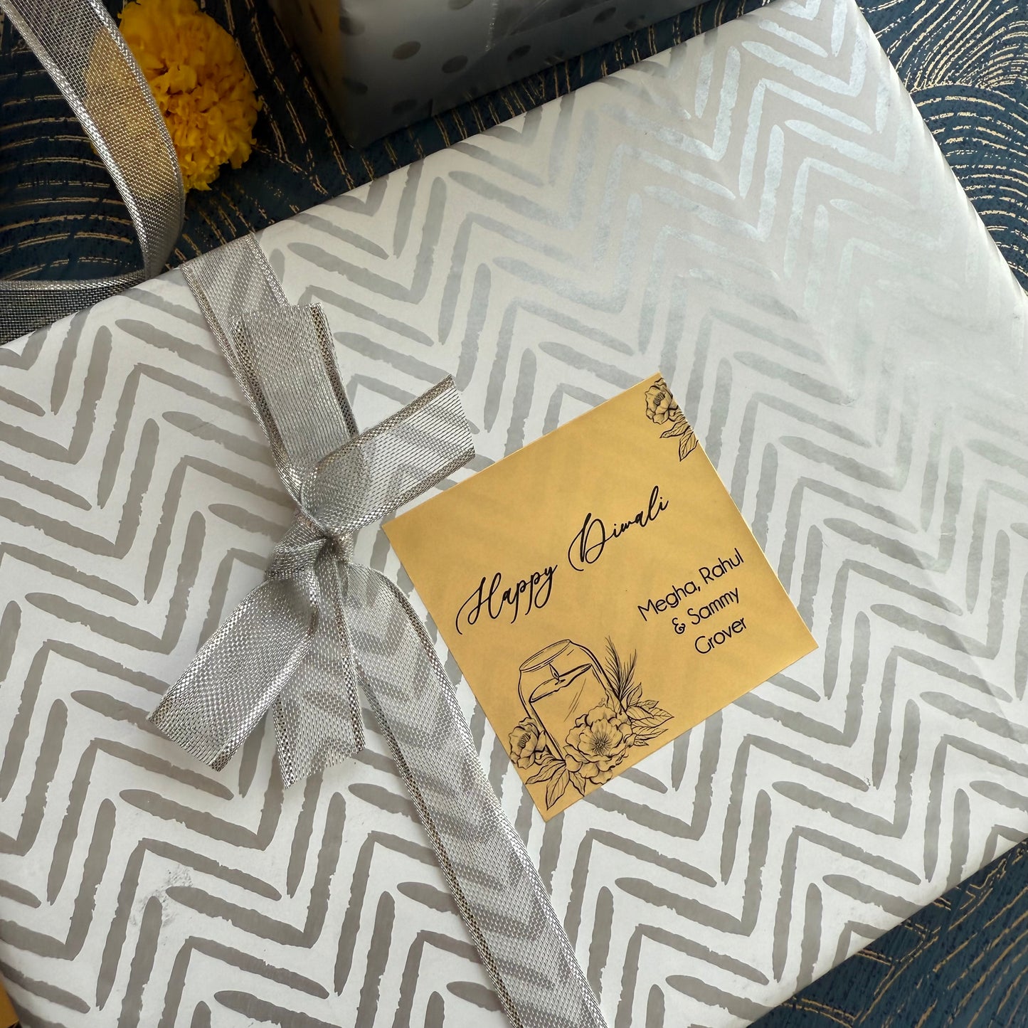 Gift box with chevron pattern and a decorative tag on a textured surface