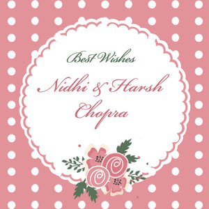 A square gift label with a pink background, white polka dots, floral patterns, and text that reads 'Best Wishes Nidhi & Harsh Chopra'.