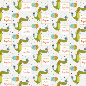 Personalised wrapping paper with a pattern of green crocodiles, blue and pink birds, and personalized text labels.