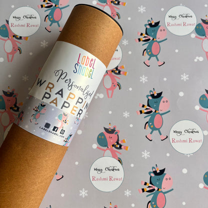 A roll of personalized wrapping paper with a dancing unicorn motif, placed on a background with various designs including snowflakes and cute creatures.