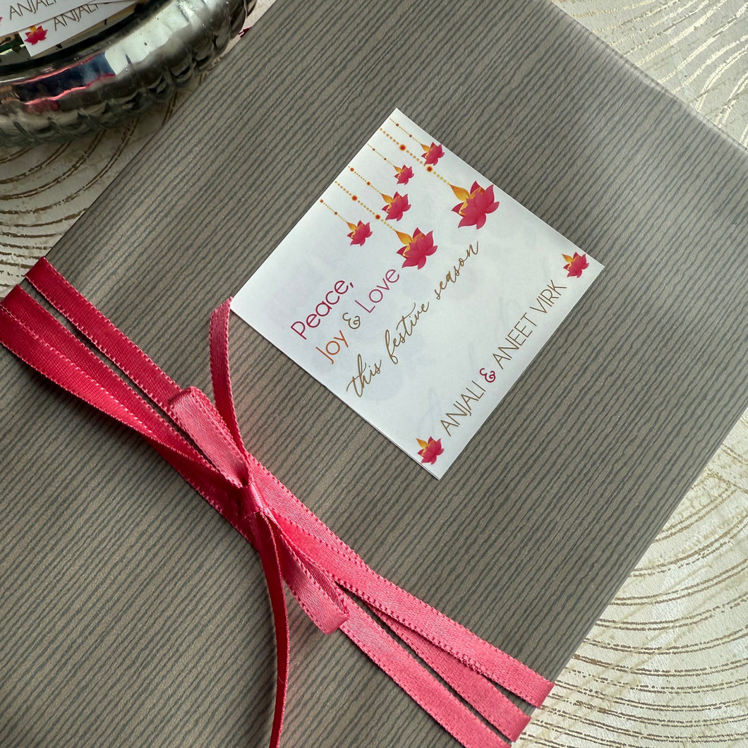Gift wrapped in brown paper with a pink ribbon and a decorative tag on a textured surface.