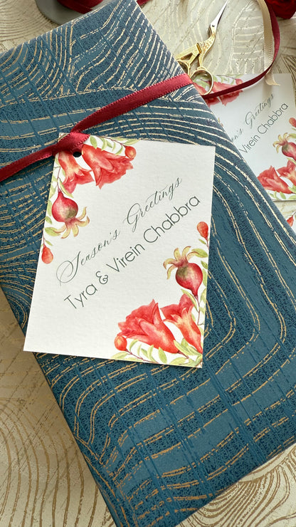 Floral gift tag on a blue textured surface with a red ribbon