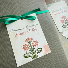 Greeting card with floral design and green ribbon on a textured surface