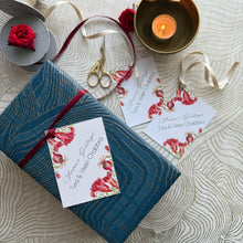 Gift box with floral card and decorative elements on a textured surface
