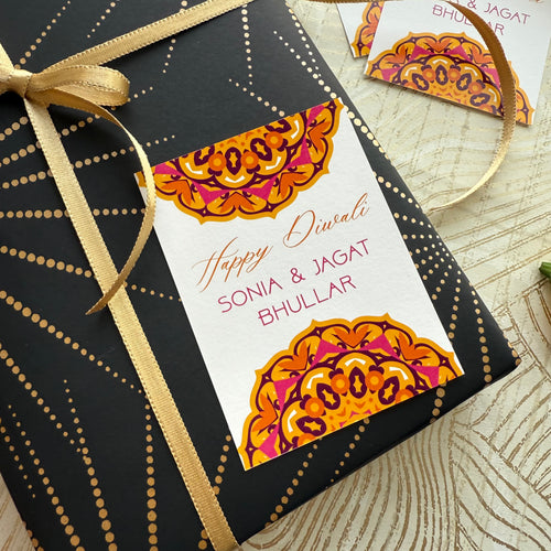 Gift box with decorative tag and gold ribbon on a textured surface