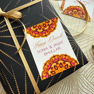 Gift box with decorative tag and gold ribbon on a textured surface