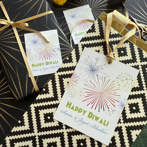 Gift cards with 'Happy Diwali' text and firework designs on a patterned surface.