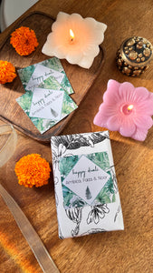 Diwali labels of green leafy design on a gift with candles in background