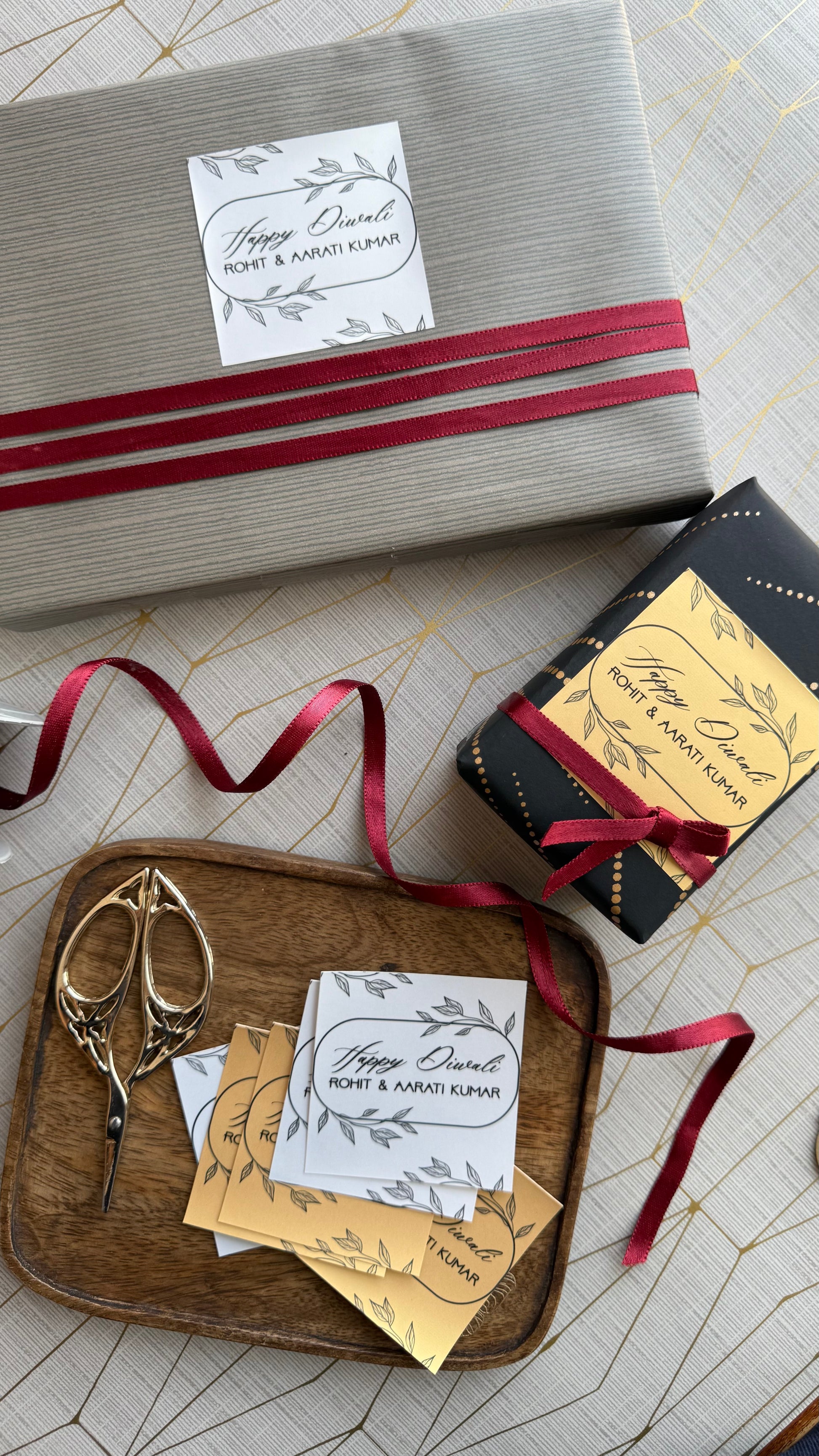 Gift box with red ribbon and decorative cards on a wooden tray