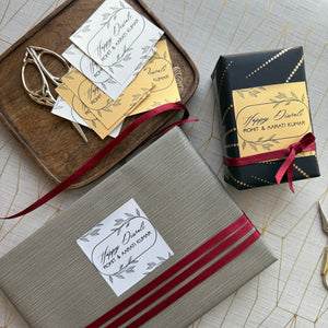 Gift boxes with personalized labels and decorative ribbons on a textured surface