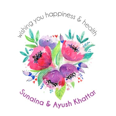 A gift label with a floral design in purple hues and text that reads 'wishing you happiness & health - Sunaina & Ayush Khattar'.