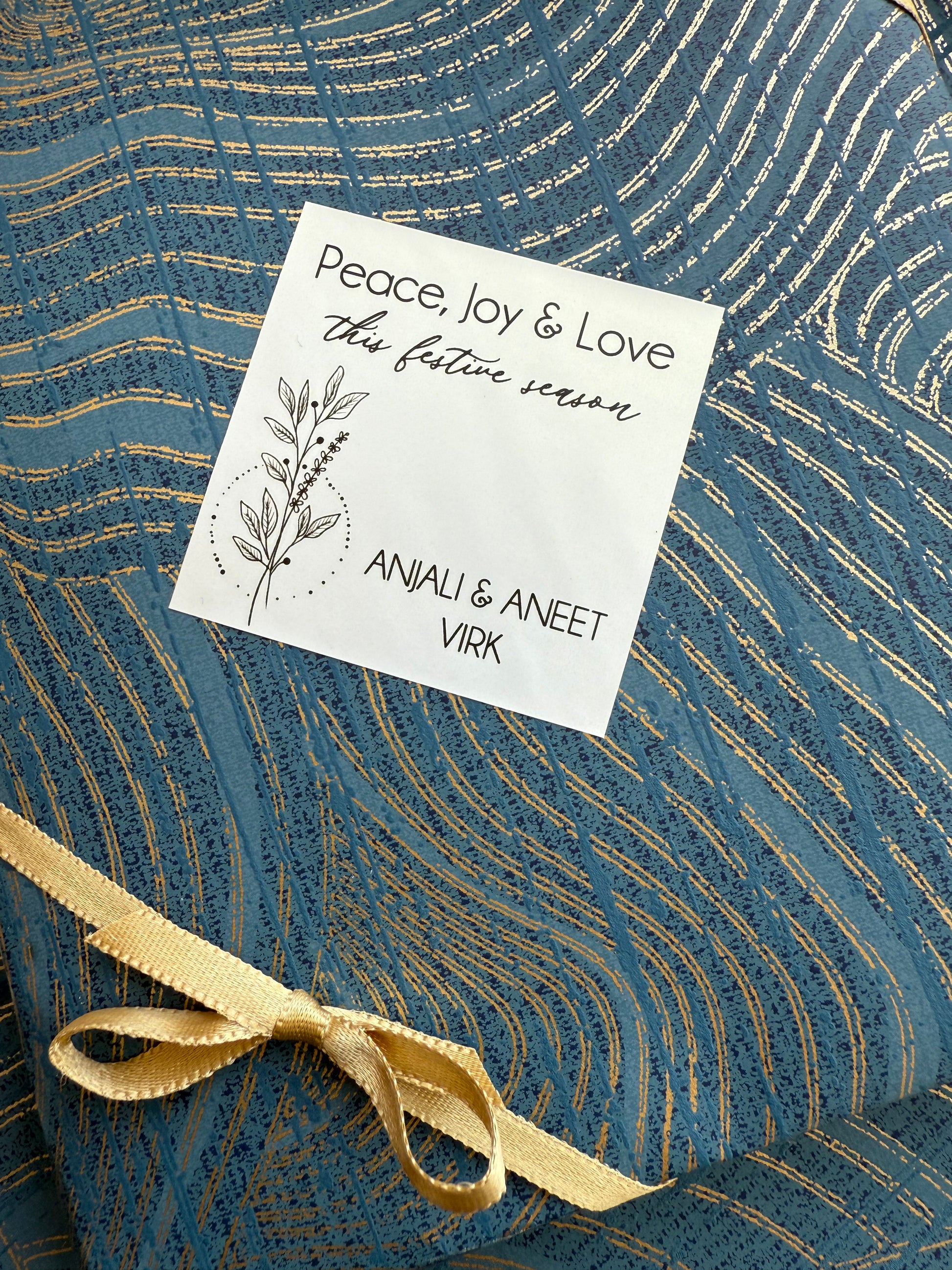 Gift tag with text and a gold ribbon on a blue textured background