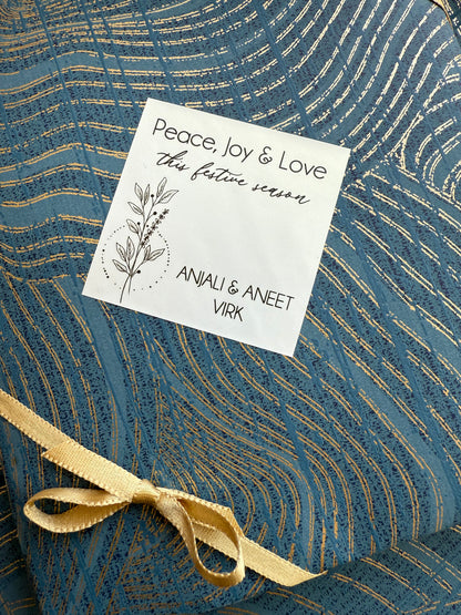Gift tag with text and a gold ribbon on a blue textured background