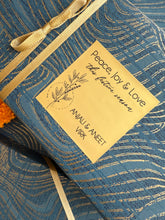 Blue gift box with gold ribbon and a decorative label on a matching blue background