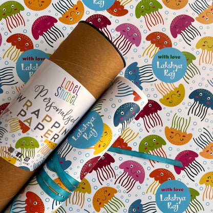A roll of wrapping paper with a colorful cartoon jellyfish pattern, shown partially unrolled over a matching sheet. 