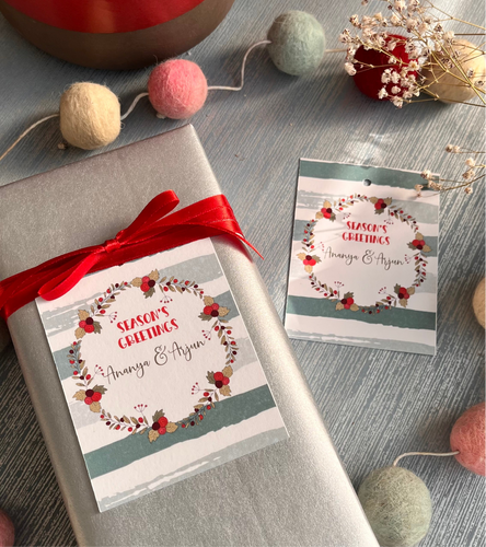 Personalized Christmas gift tags with 'Joyful' text and decorative elements, attached to a gift wrapped in silver paper.