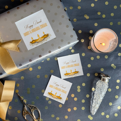 Decorative setup with gift box, cards, candle, and decorative items on a polka dot surface.