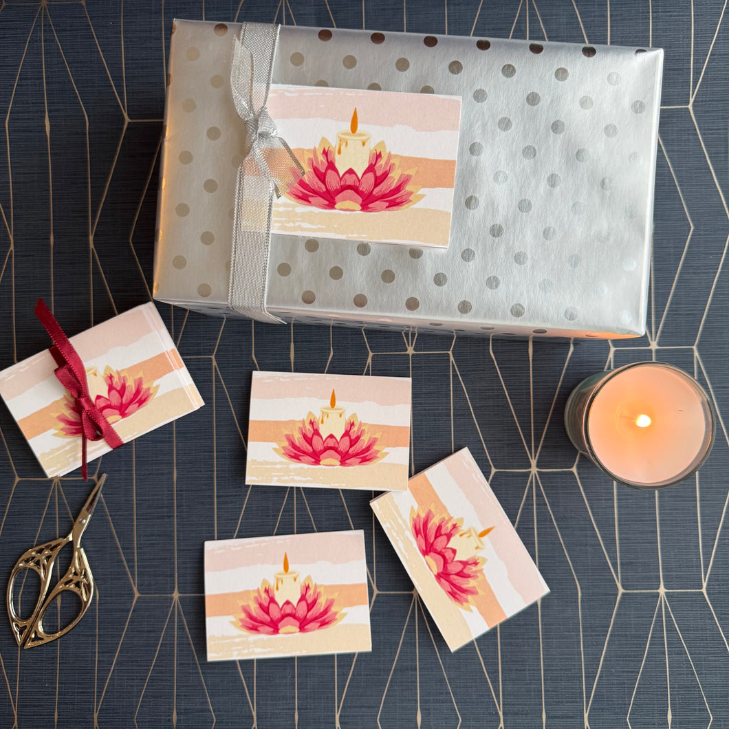 Packaged gift with matching cards on a decorative surface with a candle.