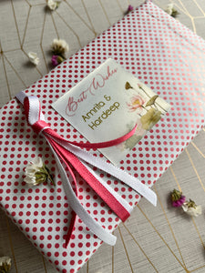 Lotus flowers and leaves  design on a gift label used on a Gift wrapped in pink and white polka dot paper with a ribbon 
