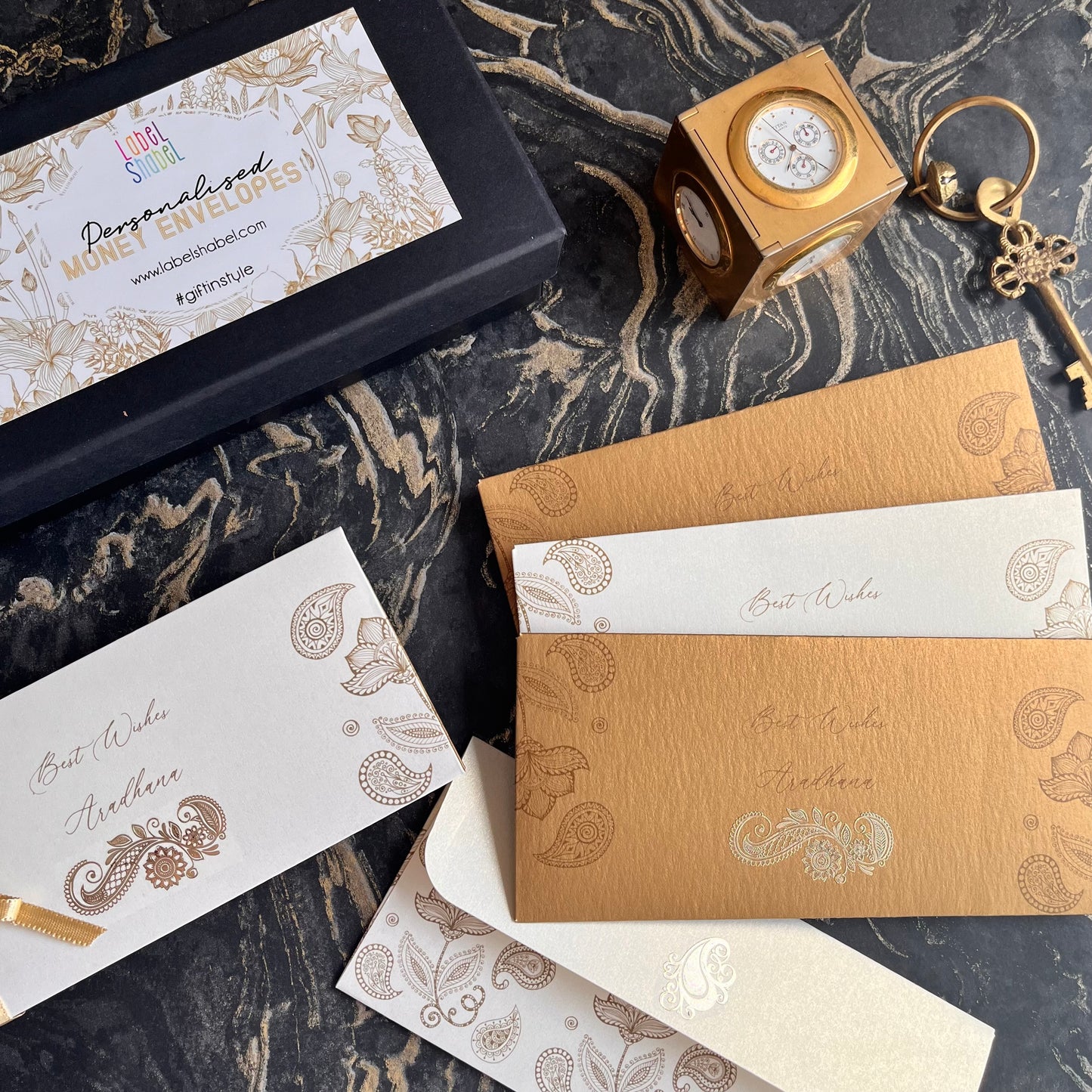 cream and gold money envelopes with metal motifs