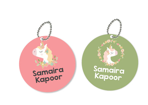 Two round metal bag tags with unicorn and floral designs, one pink and one green, with the names 'Samaira' and 'Kapoor' printed on them.