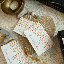 Set of cards with 'Season's Greetings' text on a decorative surface with candles and ribbons.