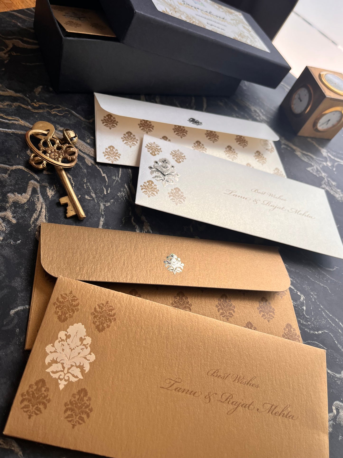 Decorative envelopes with motif design on a marble surface.