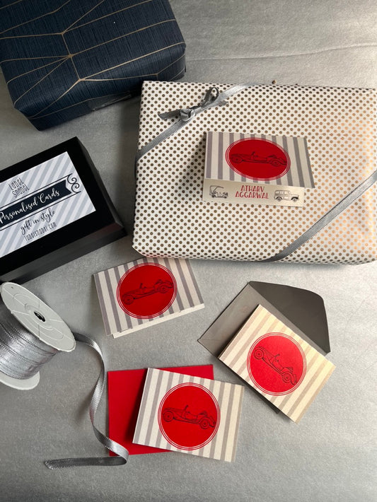 a gift wrapped in silver paper with a personalised gift tag feature a retro vintage car illustration in red and grey