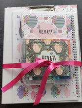 A set of clipboard, personalised crayons and note book tied together with in a pink ribbon