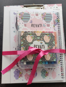 A set of clipboard, personalised crayons and note book tied together with in a pink ribbon