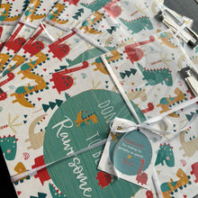 clipboards wrapped with a card and ribbon in dinosaur theme as return gifts for birthdays