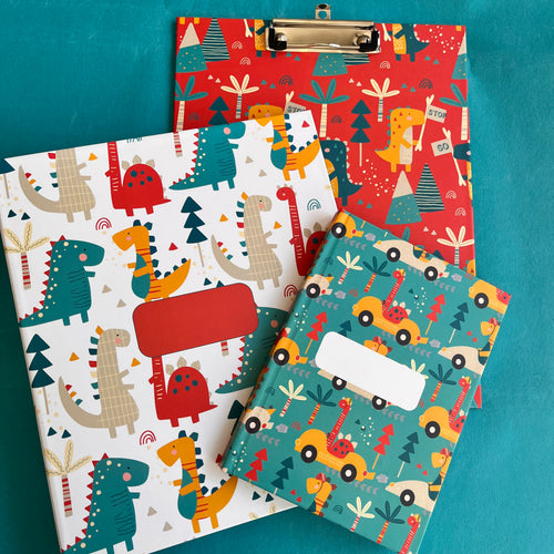 A set of school supplies with dinosaur-themed covers, including a notebook, a clipboard, and a folder, displayed on a teal background.