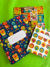 Colorful robot-patterned set of file folder, clipboard and note book on a green background