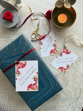 Gift box with floral ribbon and cards on a textured surface