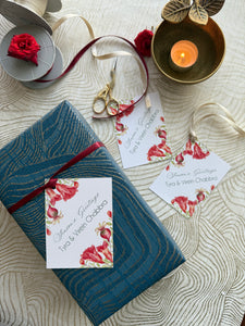 Gift box with floral ribbon and cards on a textured surface