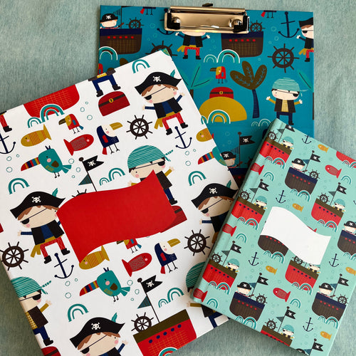 A set of school supplies with a pirate-themed design, including a notebook, a clipboard, and a folder, each featuring colorful illustrations of pirates, ships, and sea creatures.