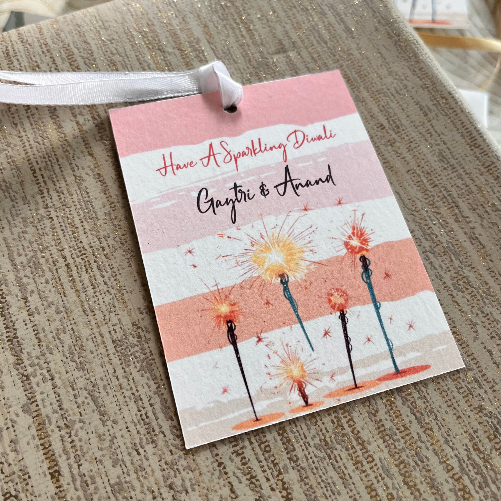 pink striped background with sparklers and a diwali wish