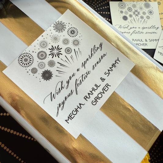 Gift box with gold and white stripes and a personalized card on a black background